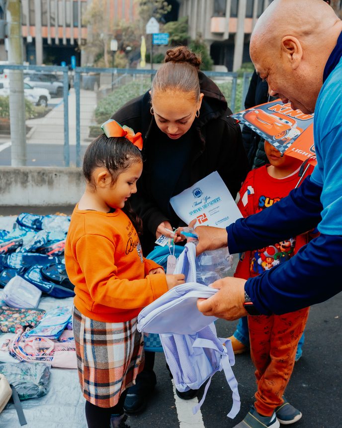 A student receiving a new backpack at Family Resource Day