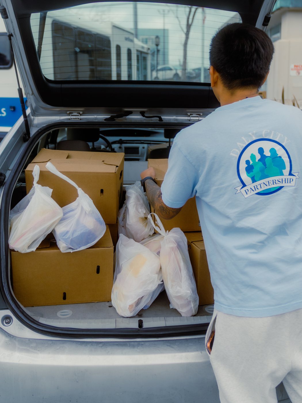 A volunteer loading Project DASH grocery deliveries into a car