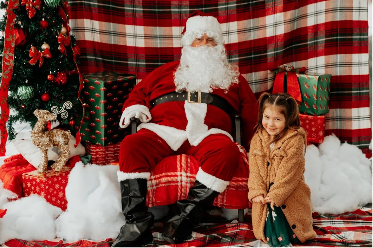A child smiling with Santa at the holiday toy celebration