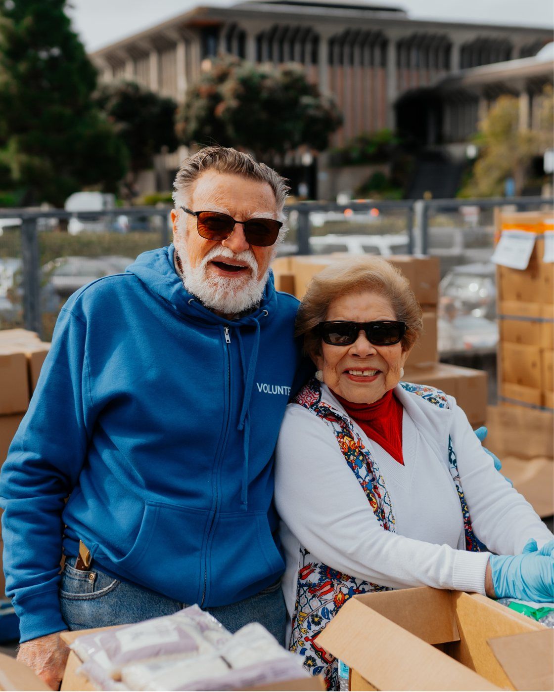 A senior couple smiling together at a community distribution