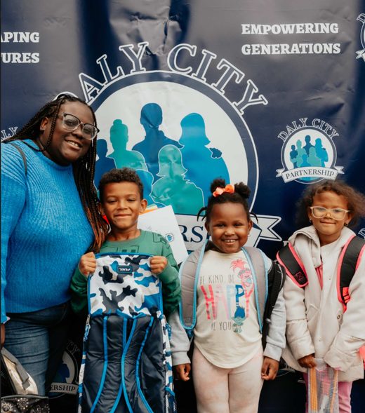Kids smiling with their new backpacks at Family Resource Day