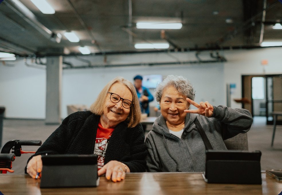 Two smiling participants with their tablets at a HART digital literacy session